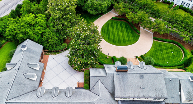 The old asphalt driveway received one of the biggest upgrades, becoming a new exposed aggregate driveway with granite cobble curbing. Champion says washing the contaminants out of the aggregate that was chosen was a huge task. (Photo: Myatt Landscaping and Construction)